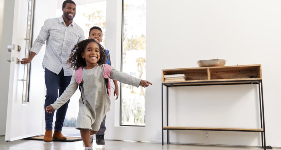 Father and kids walking through the front door